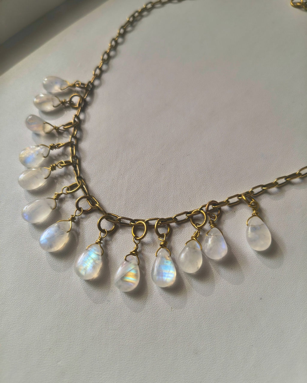 Bohemian style handmade moonstone necklace with cascading gemstone drops and warm antique brass chain.