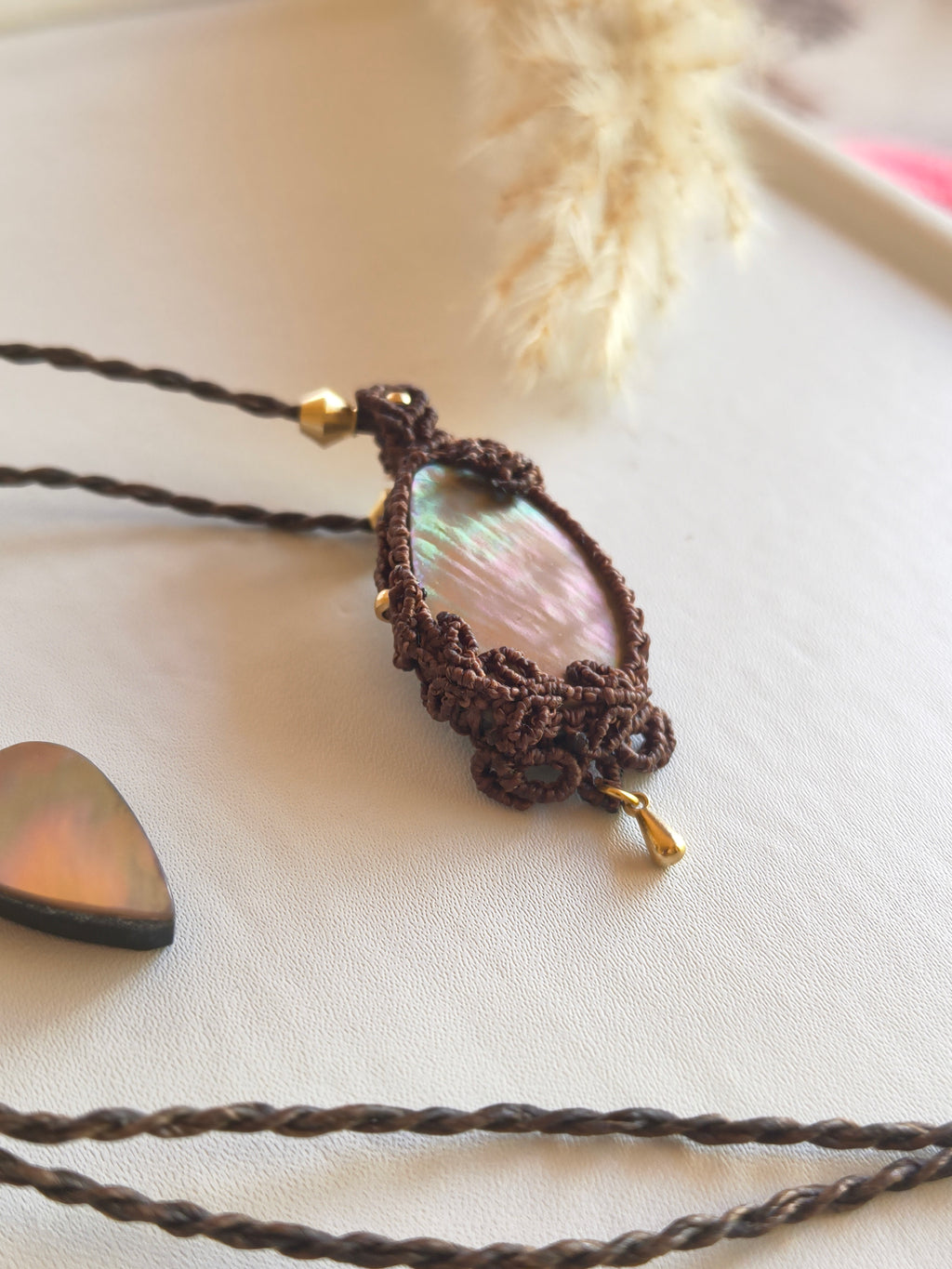 Close-up of mother of pearl showing natural iridescent sheen and leaves design on the top and side