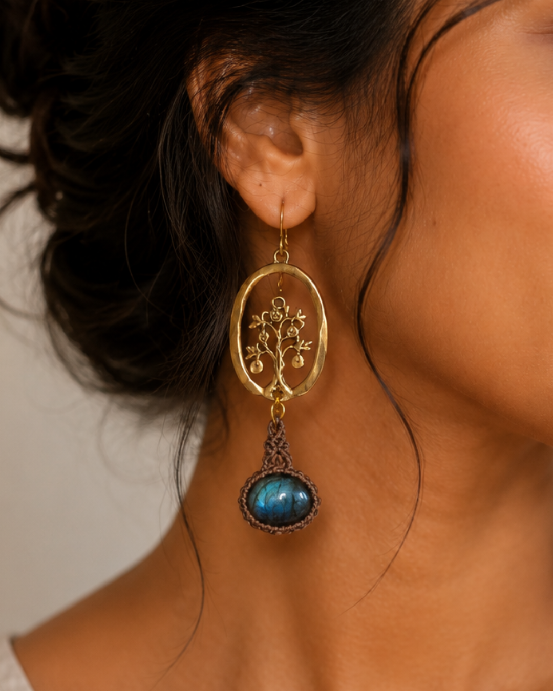 Portrait of woman wearing handmade tree of life brass and labradorite boho earrings