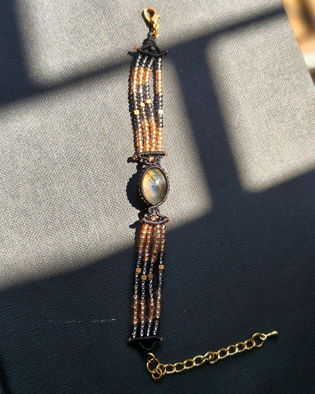 Labradorite bracelet with blue and orange flashes set in woven macrame beadwork.