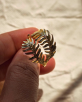 Close up of gold fern leaf ring showing delicate botanical details.