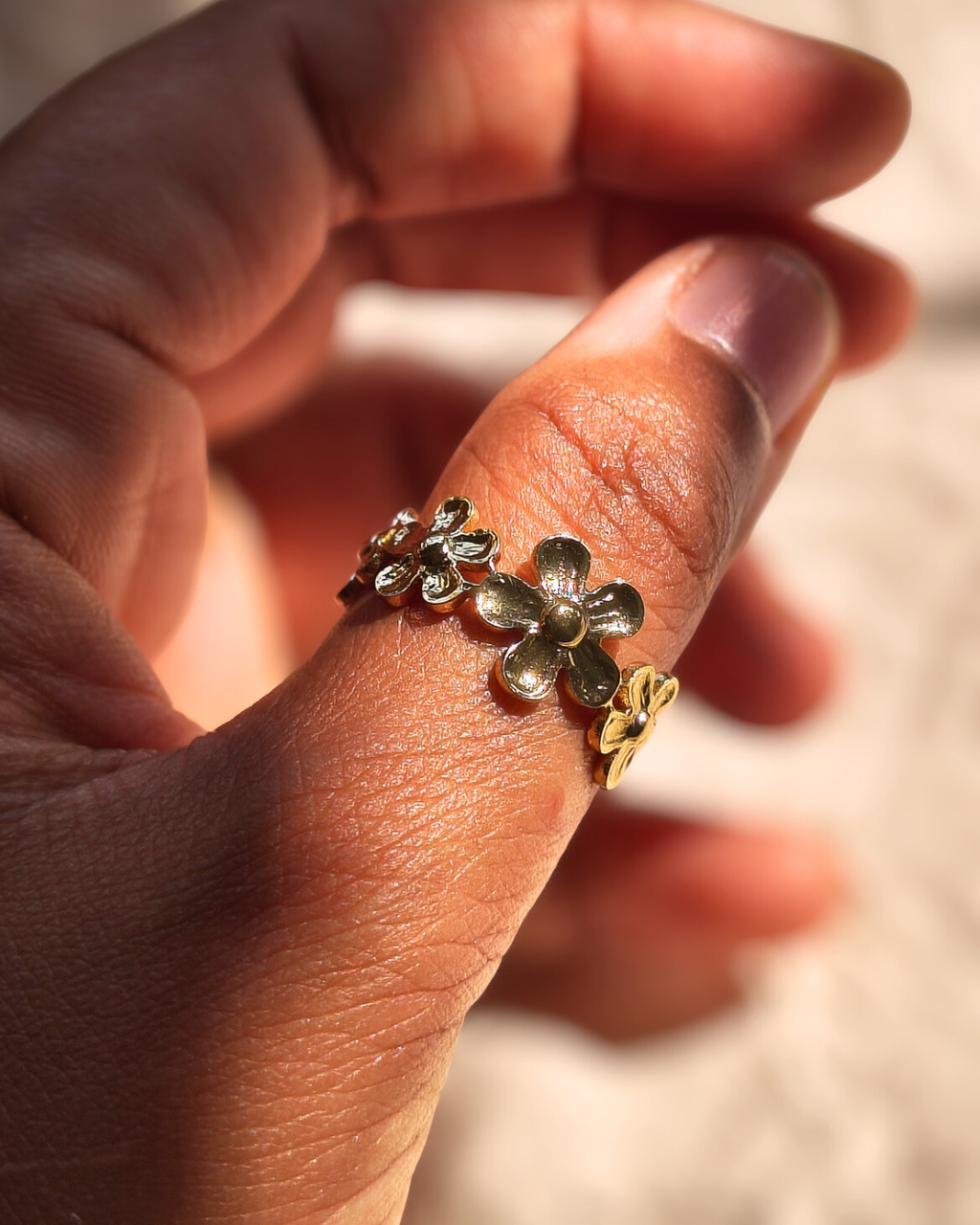 Gold floral ring with small flower design on adjustable band.