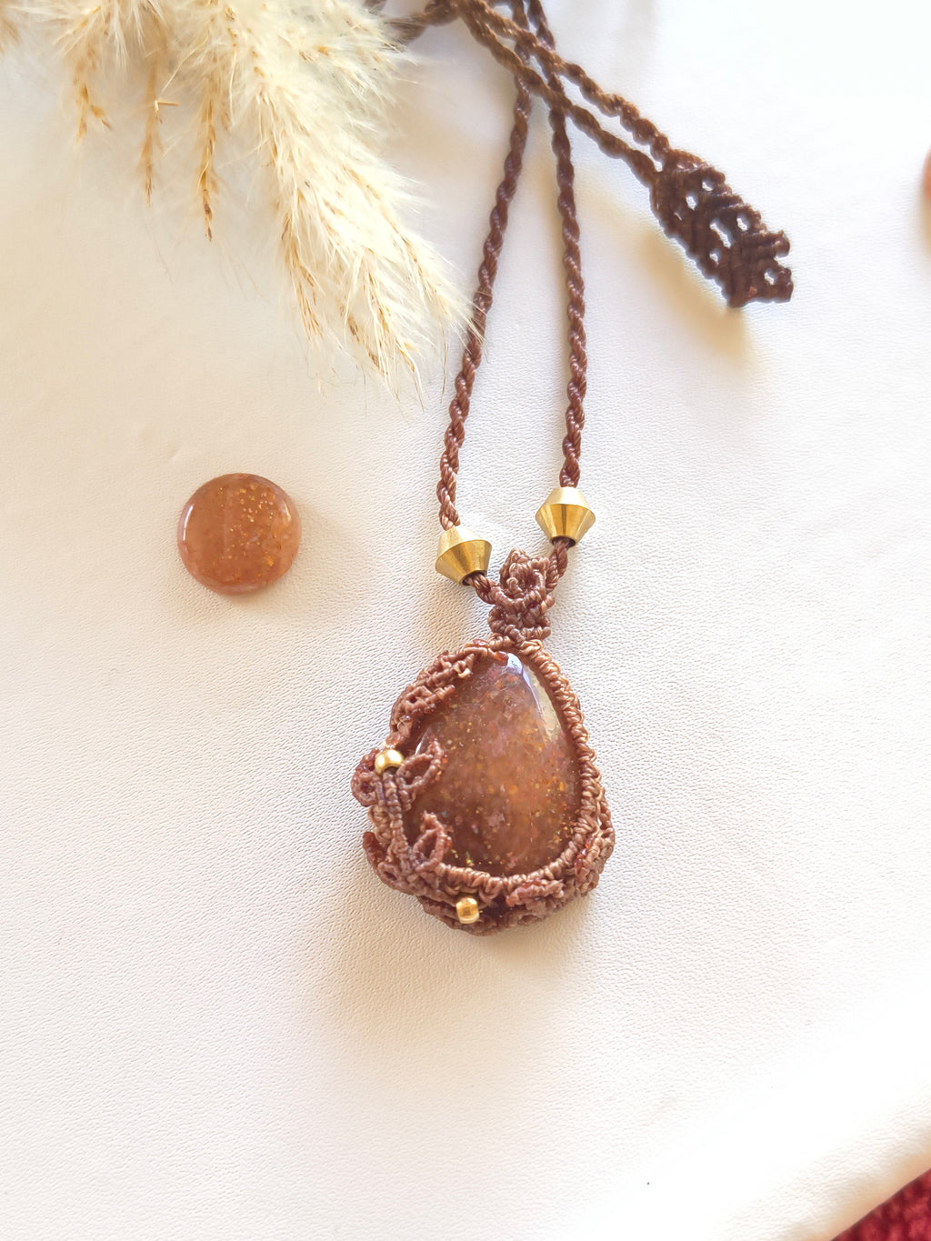 Handmade macramé with leaves detail around natural sunstone cabochon pendant