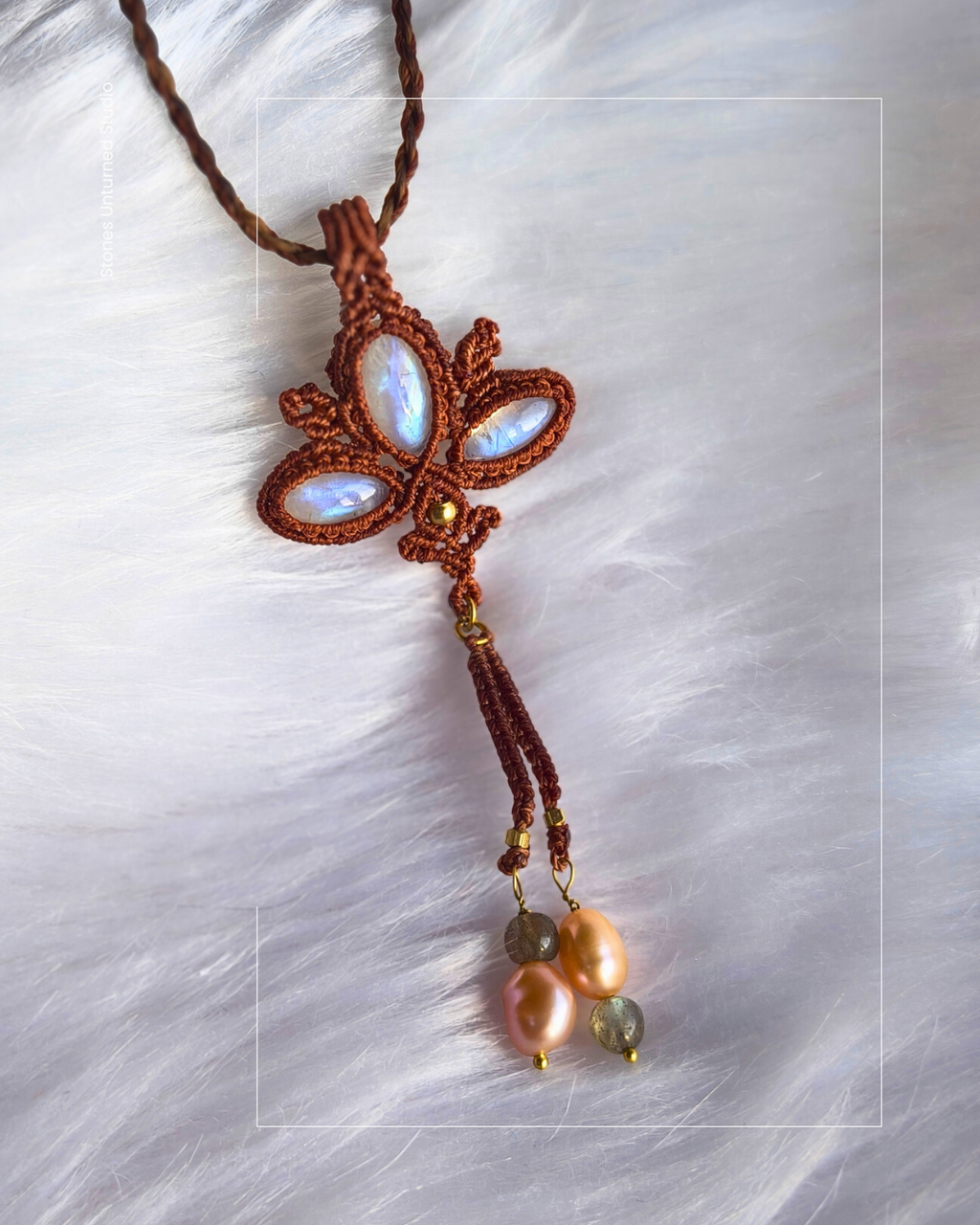 Handwoven macrame lotus pendant with glowing rainbow moonstones, copper thread, and pearl tassel 