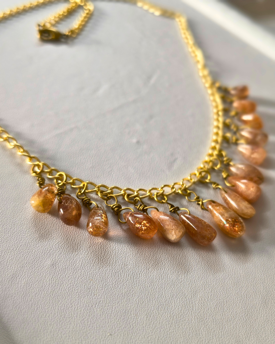 Detailed view of sparkling sunstone drops with warm peach and golden tones.