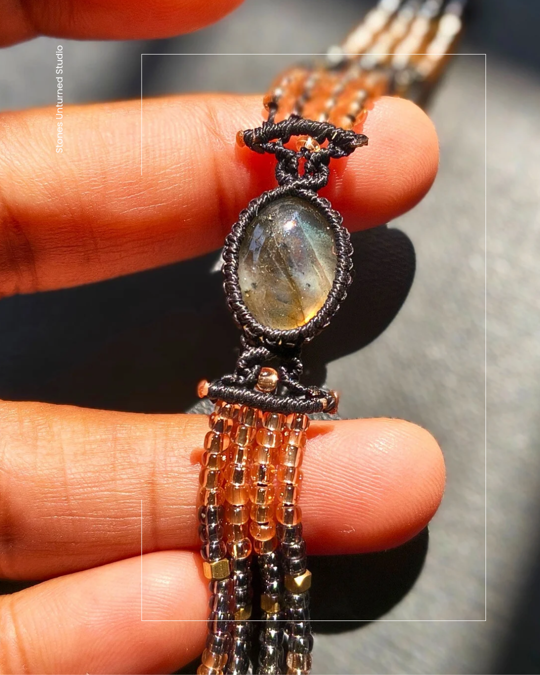 Close up of flashy labradorite stone in artisan beaded bracelet.