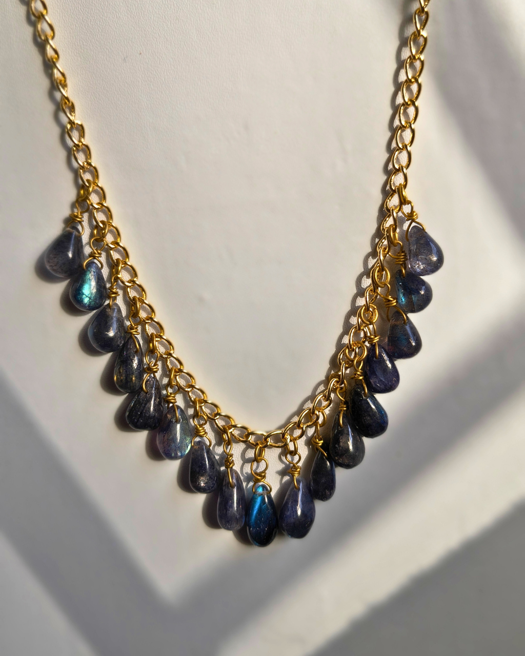 Handmade labradorite cascade necklace with natural gemstone drops suspended from a warm brass chain.