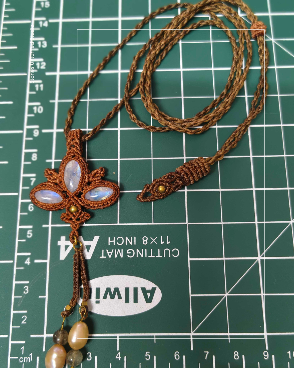 Handcrafted lotus moonstone macrame necklace showing intricate knot details and iridescent gemstone glow.