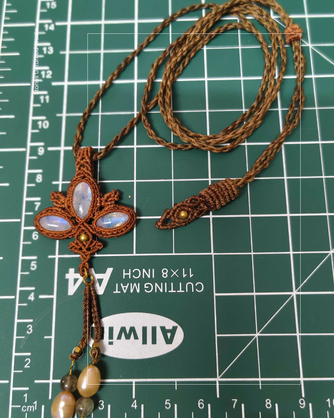 Handcrafted lotus moonstone macrame necklace showing intricate knot details and iridescent gemstone glow.
