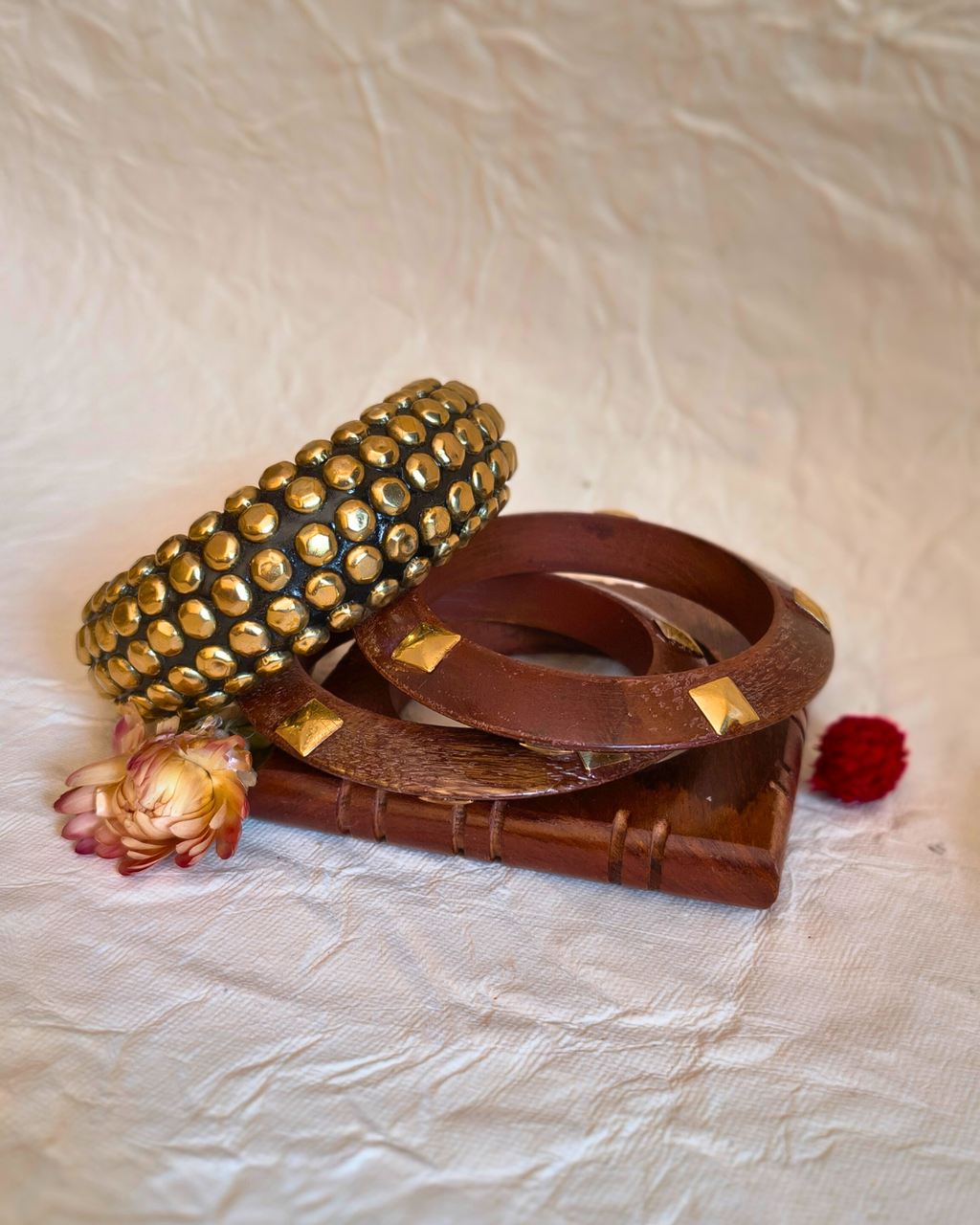 Stack of wooden bangles featuring round and rectangular designs.