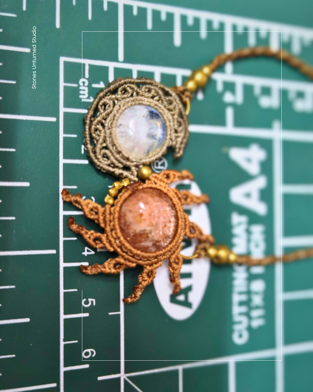 Close-up of macrame sun and moon pendant on measuring mat to show true measurements of the pandant 