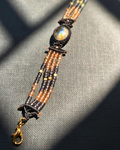 Handmade beaded bracelet with labradorite centerpiece and rose gold and grey beads.