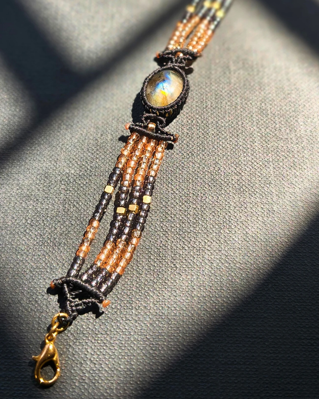 Handmade beaded bracelet with labradorite centerpiece and rose gold and grey beads.