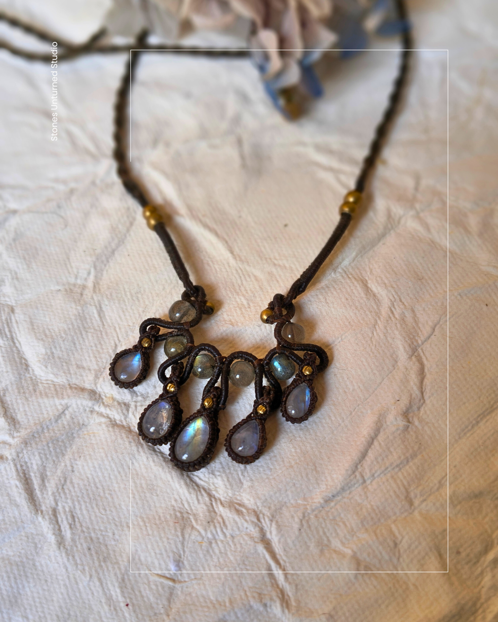 Close up of rainbow moonstone flashes in handmade macrame necklace.