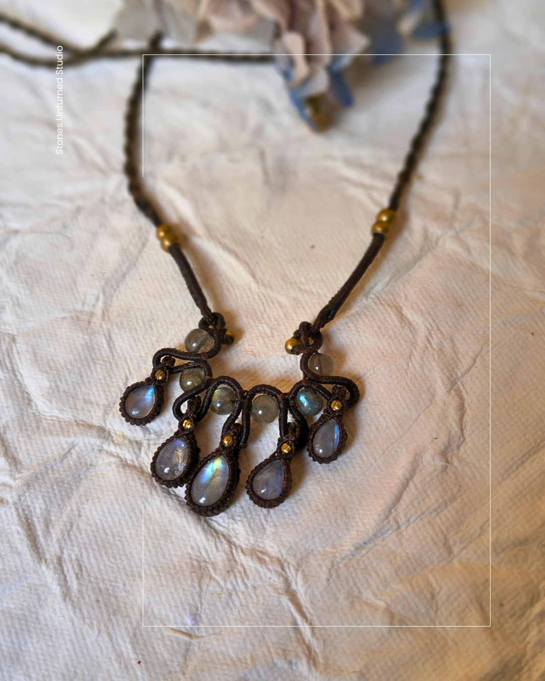 Close up of rainbow moonstone flashes in handmade macrame necklace.