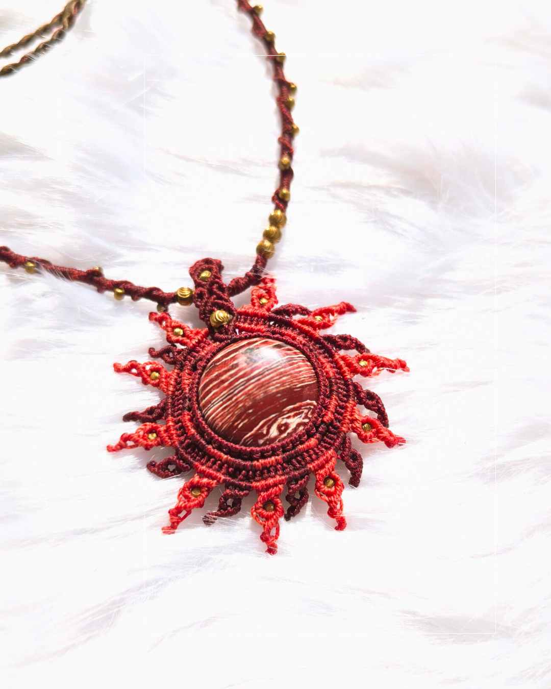 Close-up of natural rainbow jasper sun necklace with intricate macrame weaving