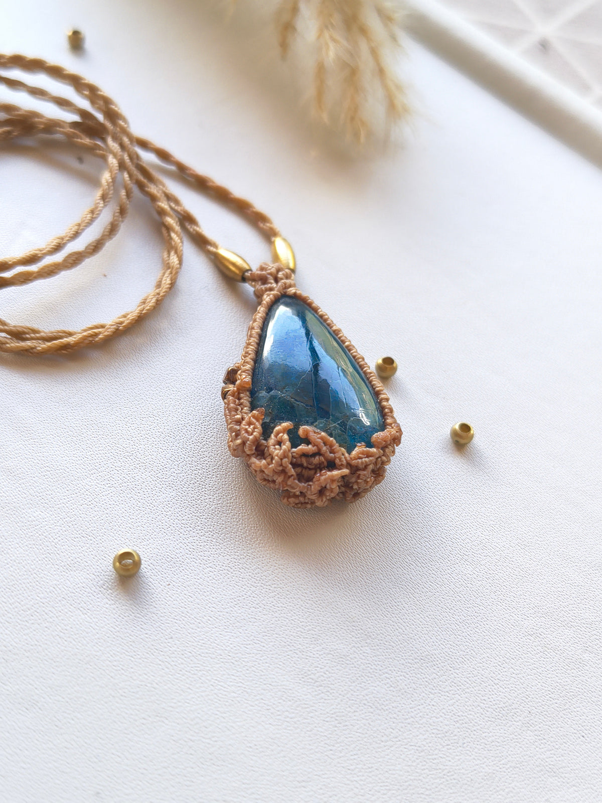 Side view of apatite macramé pendant showing the intricate leaf design and beads with blue azure stone color