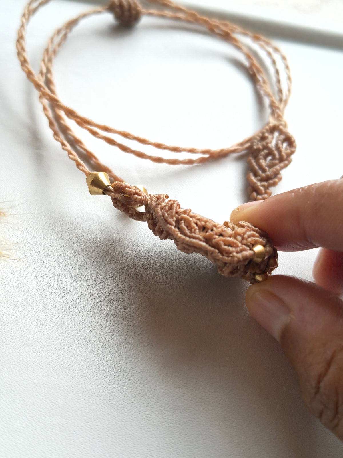 Side view of seraphinite macramé pendant showing leaf pattern and bead details 
