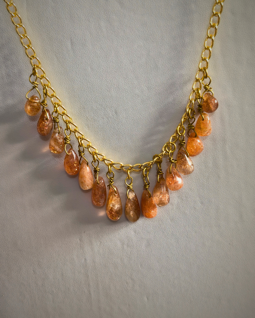 Handmade tear drop sunstone statement necklace displayed in soft natural light.