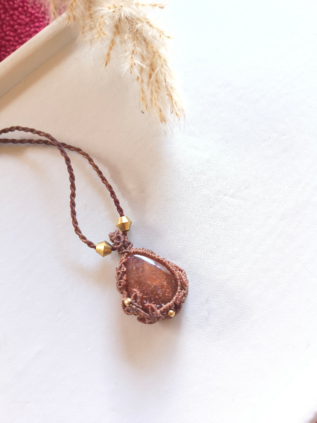 Sunstone pendant necklace with adjustable brass-capped cord show wide angle