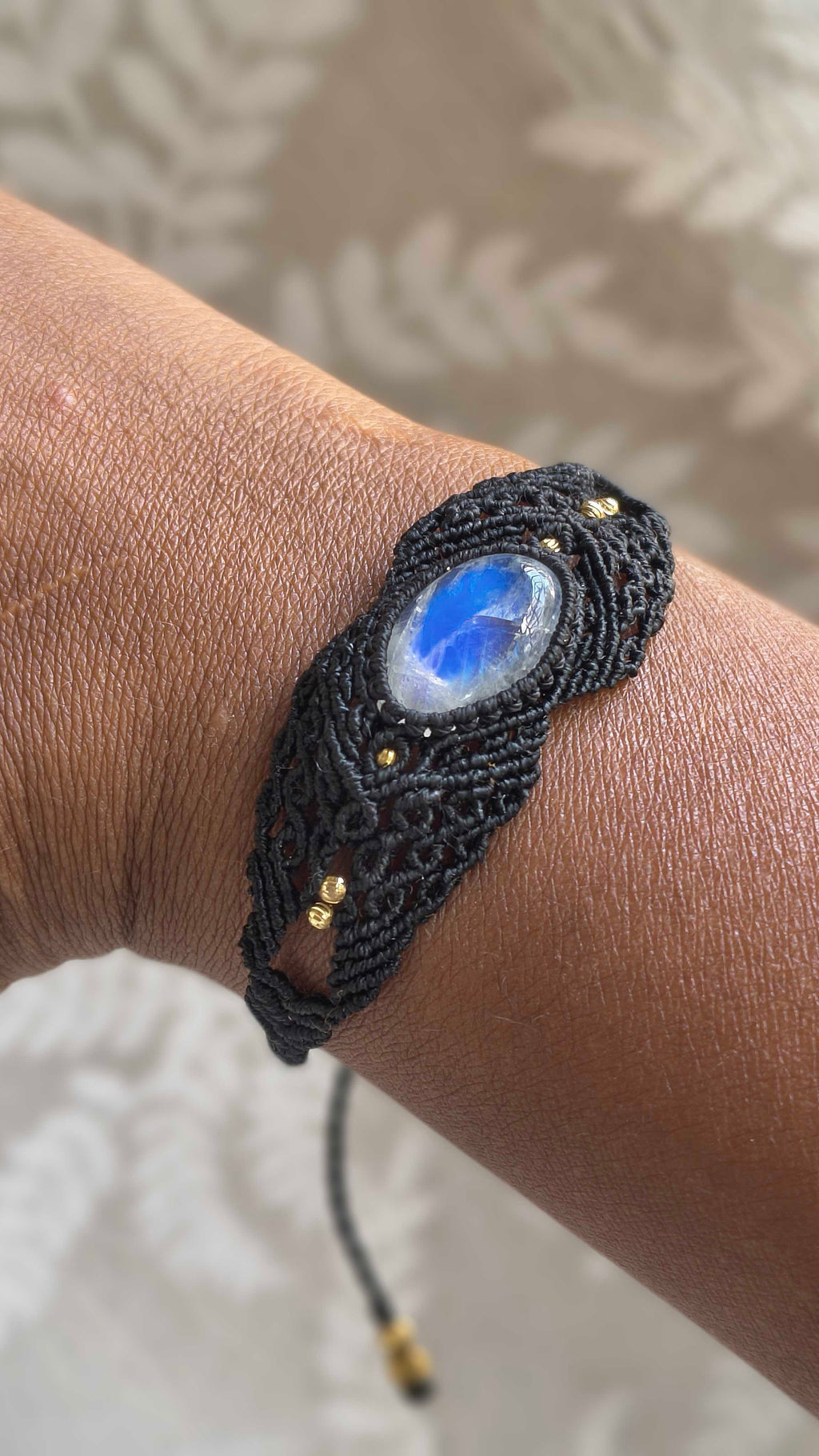 Video showing handmade black macramé bracelet with natural moonstone gemstone and intricate knotwork.
