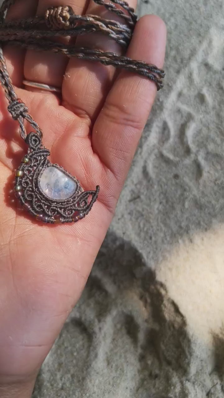 Close-up video of handmade crescent moon macramé necklace featuring natural moonstone gemstone and intricate knotwork.